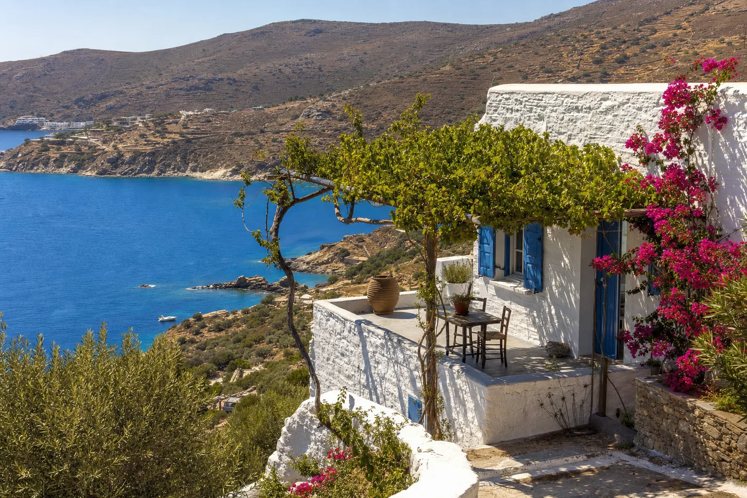 A whitewashed Greek house above a deep blue Aegean bay